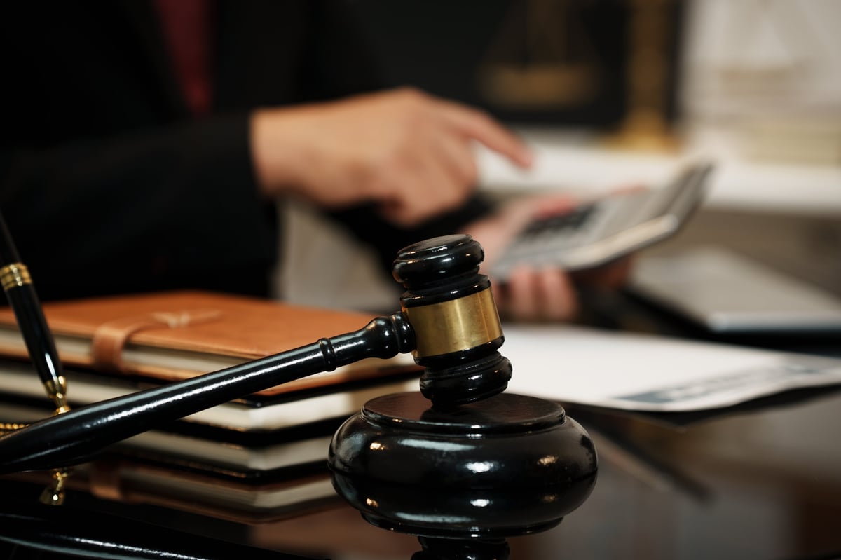 Judge's gavel on a desk with legal and financial documents in the background
