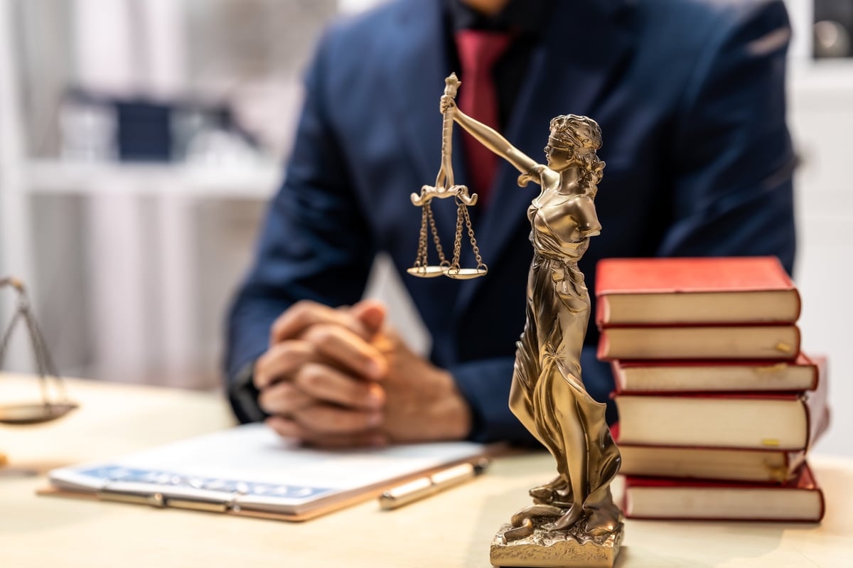Estate planning attorney's desk with scales of justice, legal books and a laptop